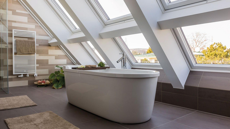 Bagno moderno con vasca da bagno vrijstaande collocata davanti een diverse finestre che arrivano fino al pavimento