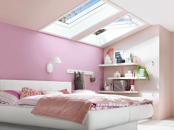 Twee RotoQ-klapbare ramen overspoelen een slaapkamer met veel licht.