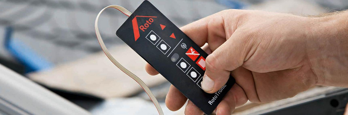 Eén hand leert één kanaal op een afstandsbediening van een RotoTronic-raam.