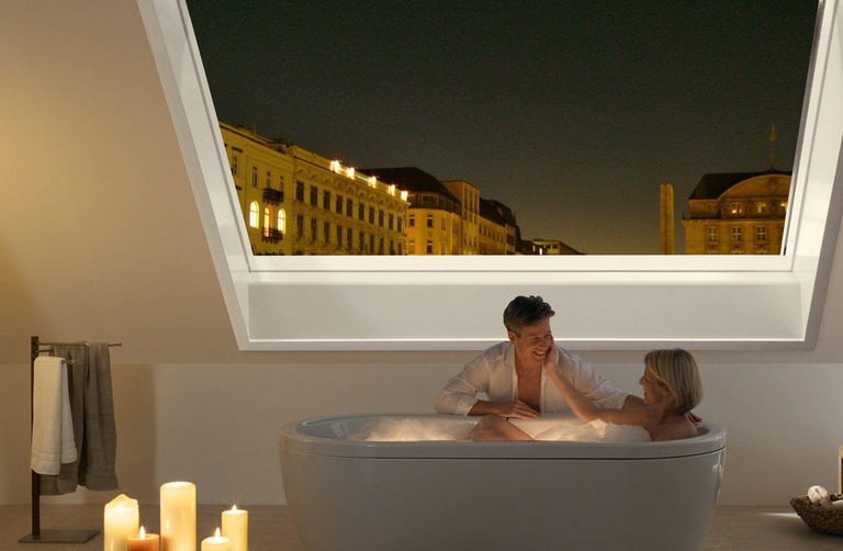 Una finestra panoramaica per tetti Azuro aperta sul cielo notturno crea un'atmosfera romantica nel bagno