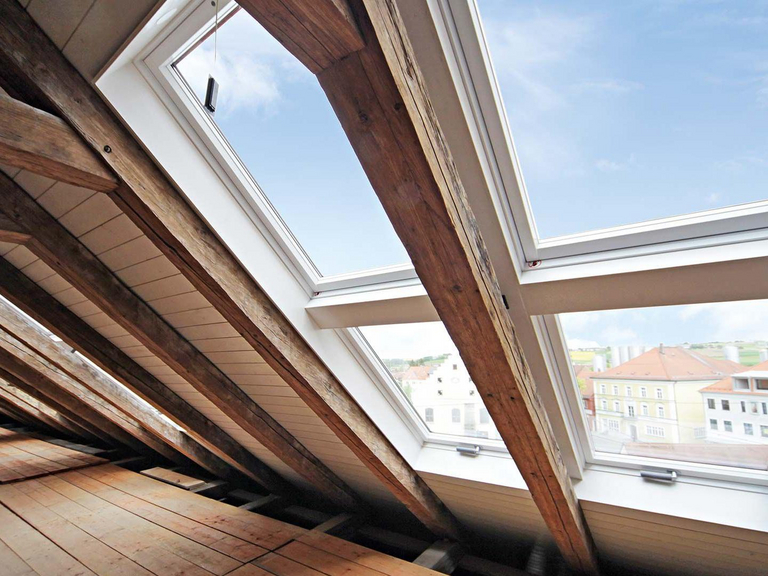 Bovenverdieping met oude houten balken en diverse dakramen 