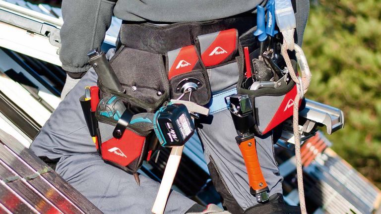 Close-up van een service-expert met gereedschapsriem op een dak