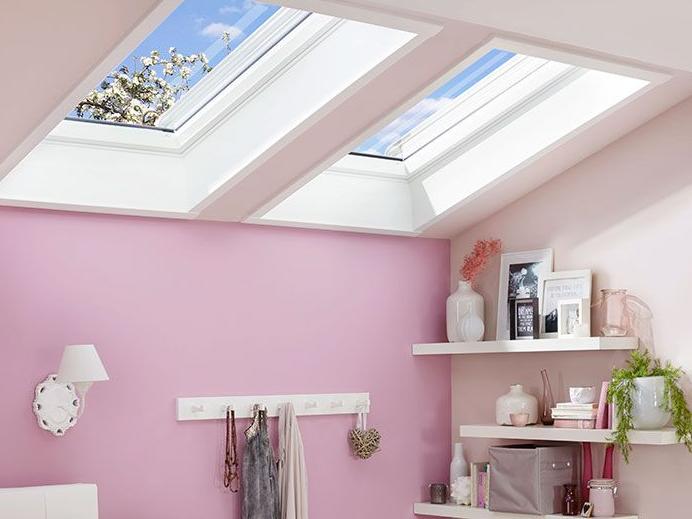 Twee RotoQ-klapbare ramen overspoelen een slaapkamer met veel licht.